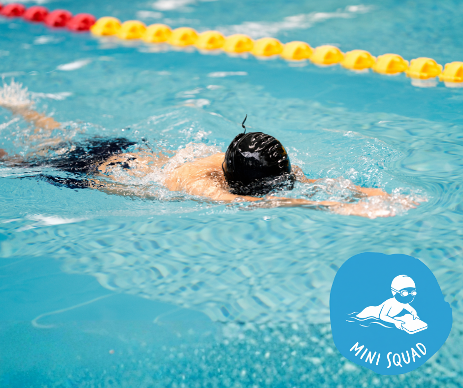 Swimmer in black swim trunks and white cap, doing the freestyle stroke in a blue pool.
