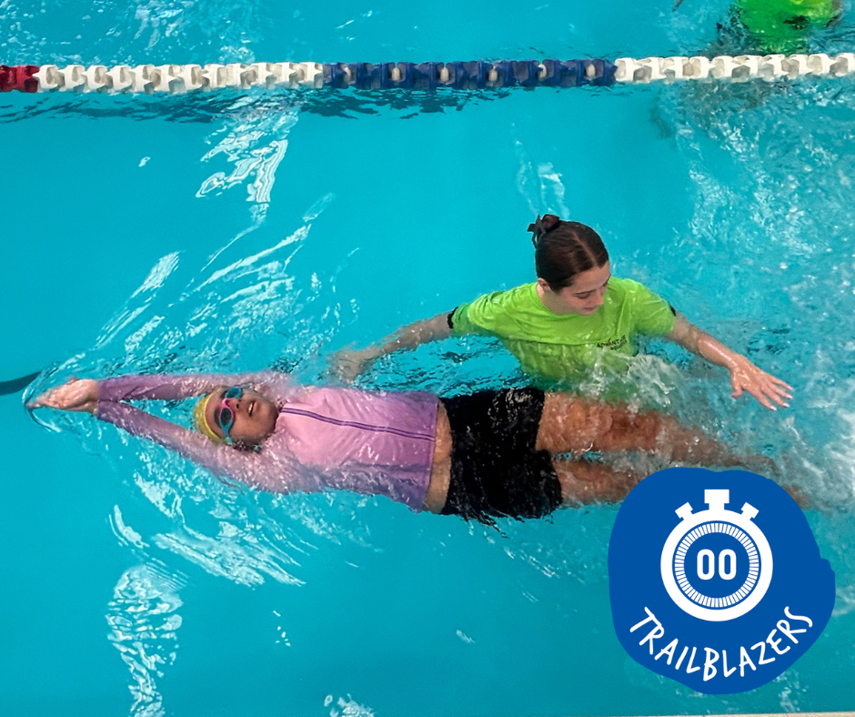 Swimmer in a white cap and goggles, performing the freestyle stroke in a pool.