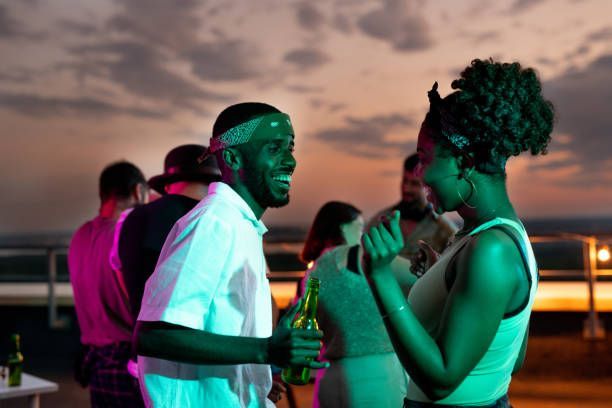 A man and a woman are standing next to each other at a party.