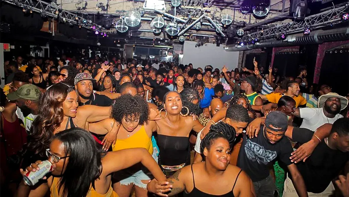 A large crowd of people are dancing in a club