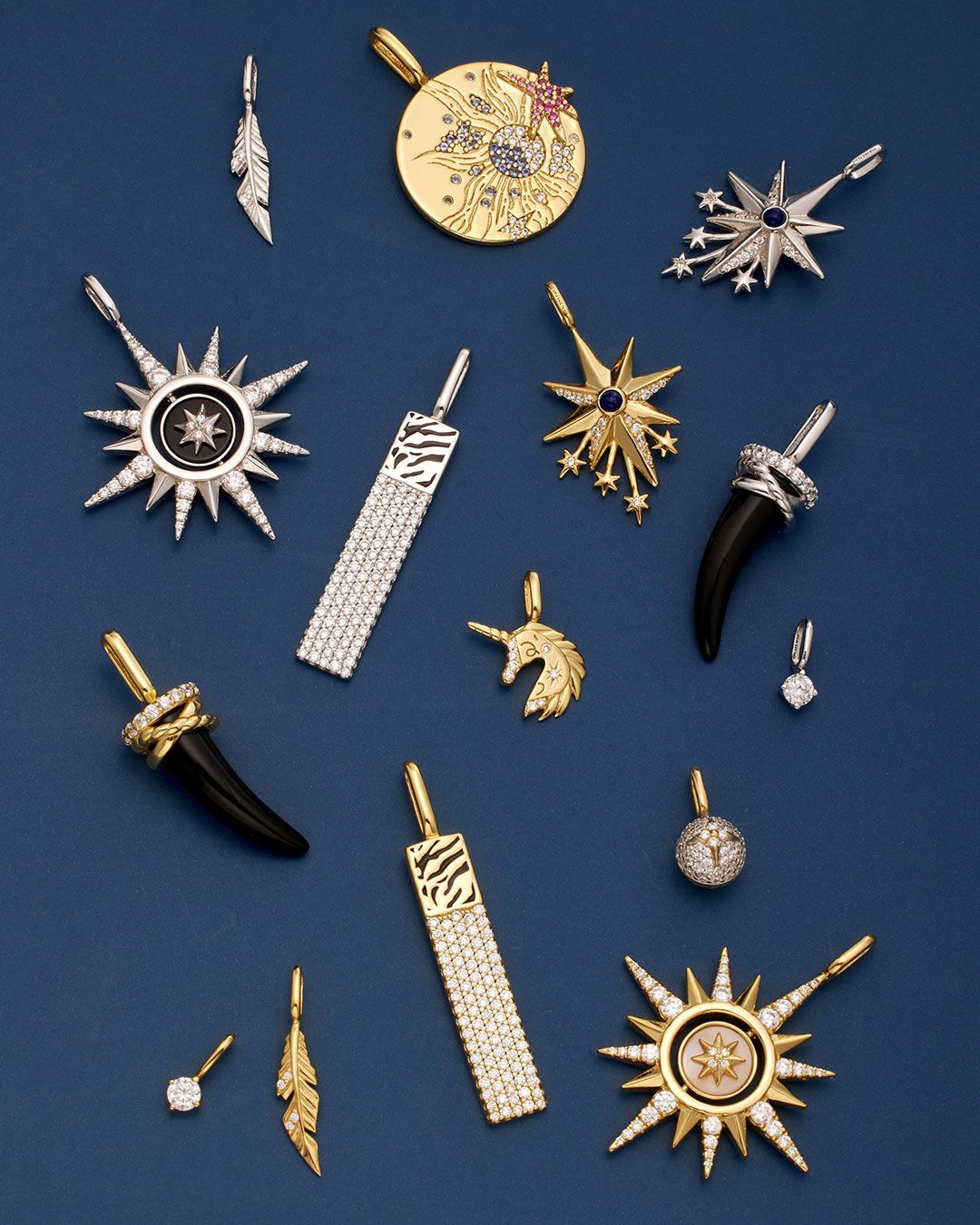 Pendentifs de bijoux : en or, en argent, sertis de pierres précieuses et en forme de corne sur fond bleu foncé.