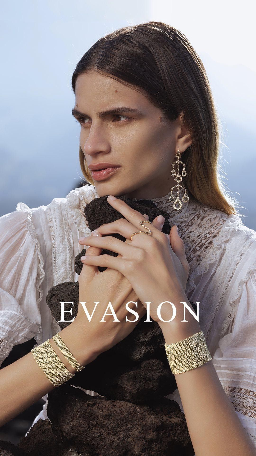 Femme portant des bijoux, une robe blanche et une pierre, en extérieur. Texte « ÉVASION ».