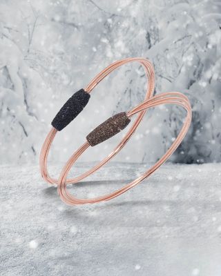 Deux bracelets en argent avec des accents de perles colorées, sur fond d'aurores boréales.