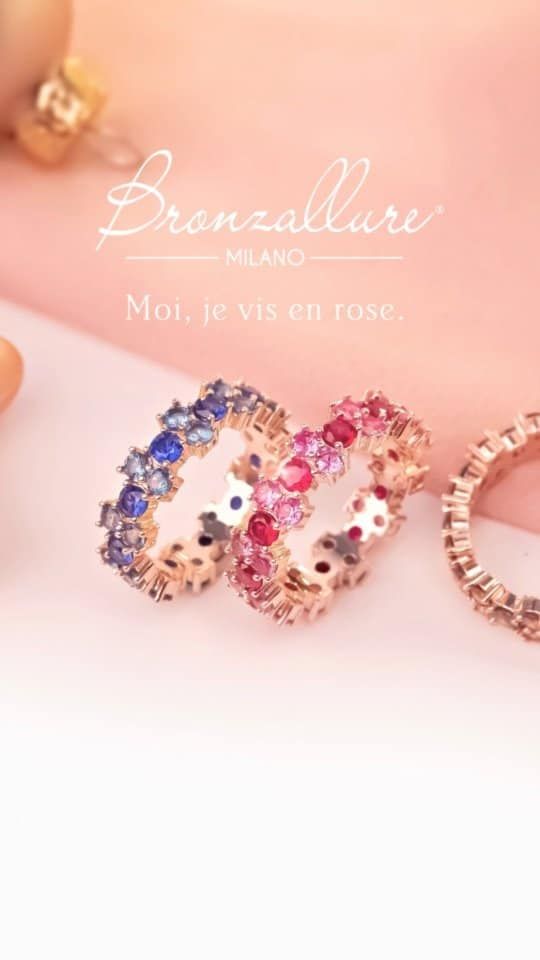 Trois bagues Bronzallure MILANO avec des pierres colorées sur fond rose.