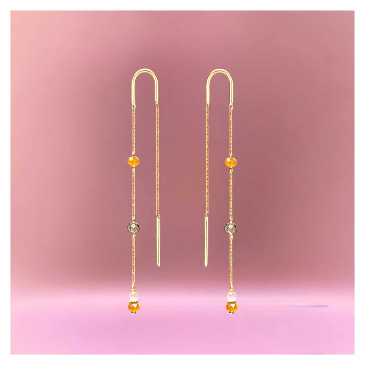 Boucles d'oreilles en or avec pierres précieuses orange et transparentes.