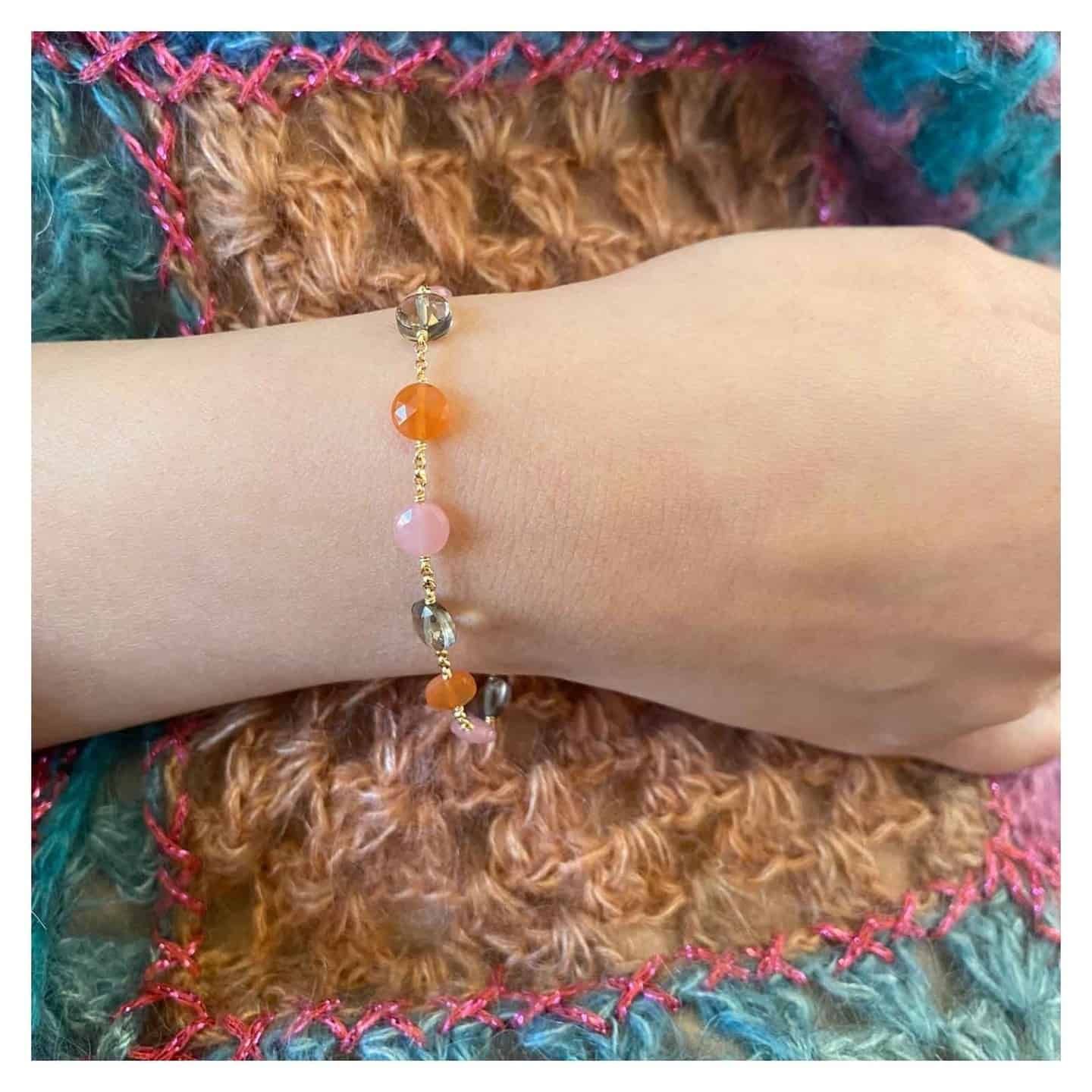 Bracelet de poignet pour femme avec chaîne en or ornée de perles de pierres précieuses colorées.