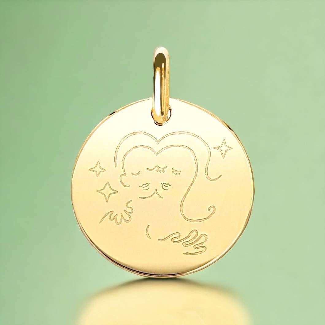 Pendentif en or avec un motif en relief d'un Capricorne stylisé, la chèvre astrologique, sur fond vert.