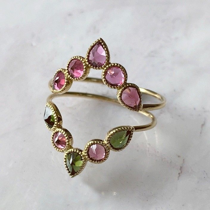 Bague en or avec pierres précieuses de tourmaline rose et verte dans un design incurvé.