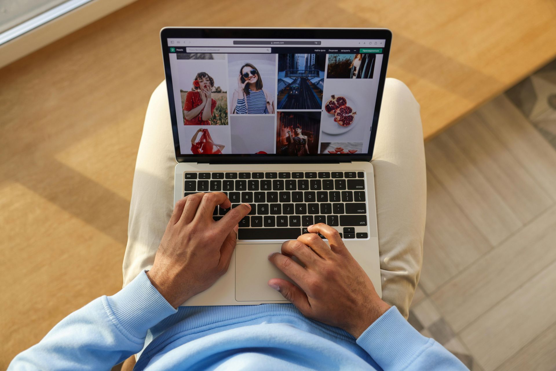 A man is sitting in a chair using a laptop computer.
