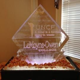 Ice sculpture with UNCF and LeMoyne-Owen College logos, lit from below on a table.