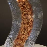 Close-up of orange shrimp packed inside a transparent, textured ice sculpture