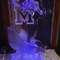 LED-lit glass sculpture with a large “M” and cougar logo in purple light