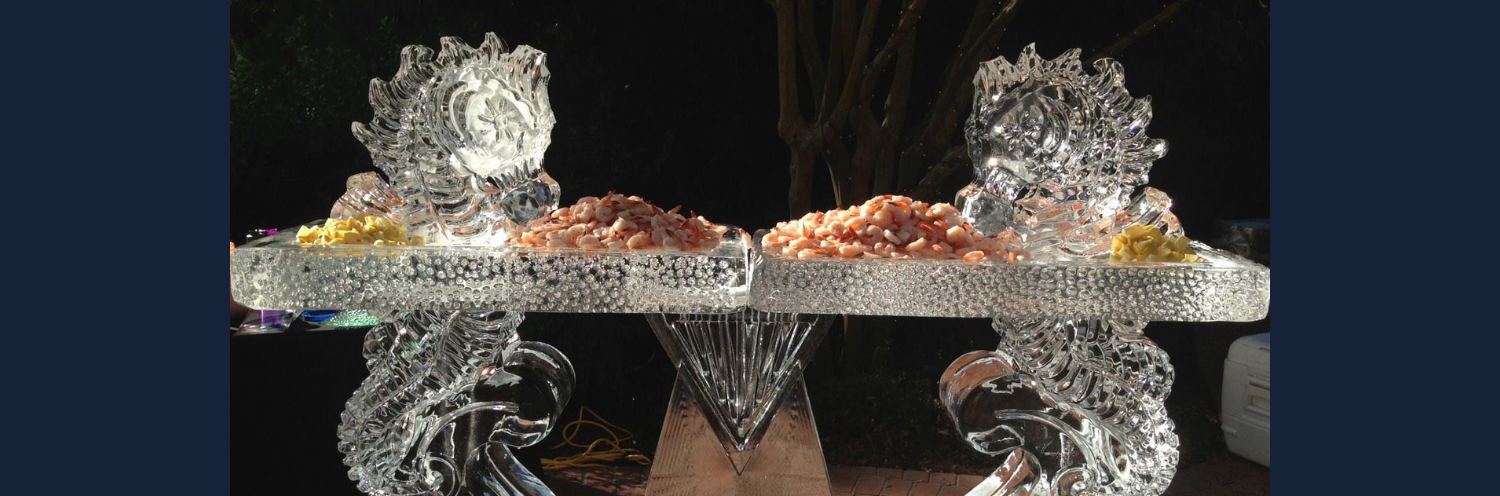 A glittering silver and orange decorative centerpiece with mirrored crystal-like ice sculptured sea horses