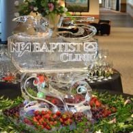 NEA Baptist Clinic ice sculpture centerpiece with flowers and strawberries in a lobby