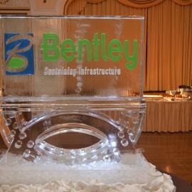 Clear acrylic Bentley podium with green logo on a white tablecloth in a banquet hall