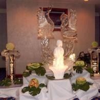 White statue in front of a two towered ice sculpture of swans
