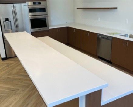 Storage unit hallway with rows of metal doors and a wood-look floor.