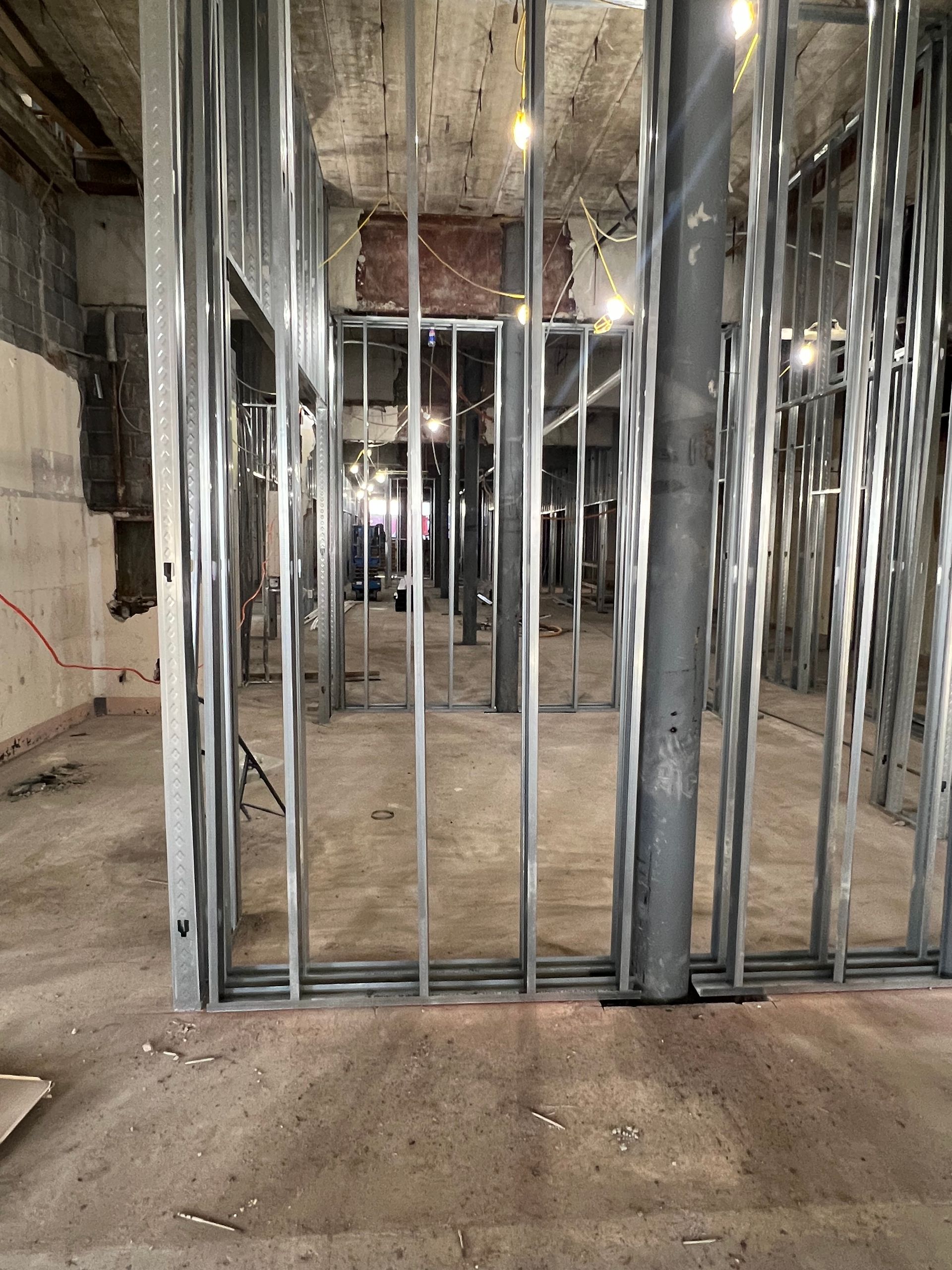 Metal framing for interior walls in a construction site. Concrete floor and ceiling, metal columns.