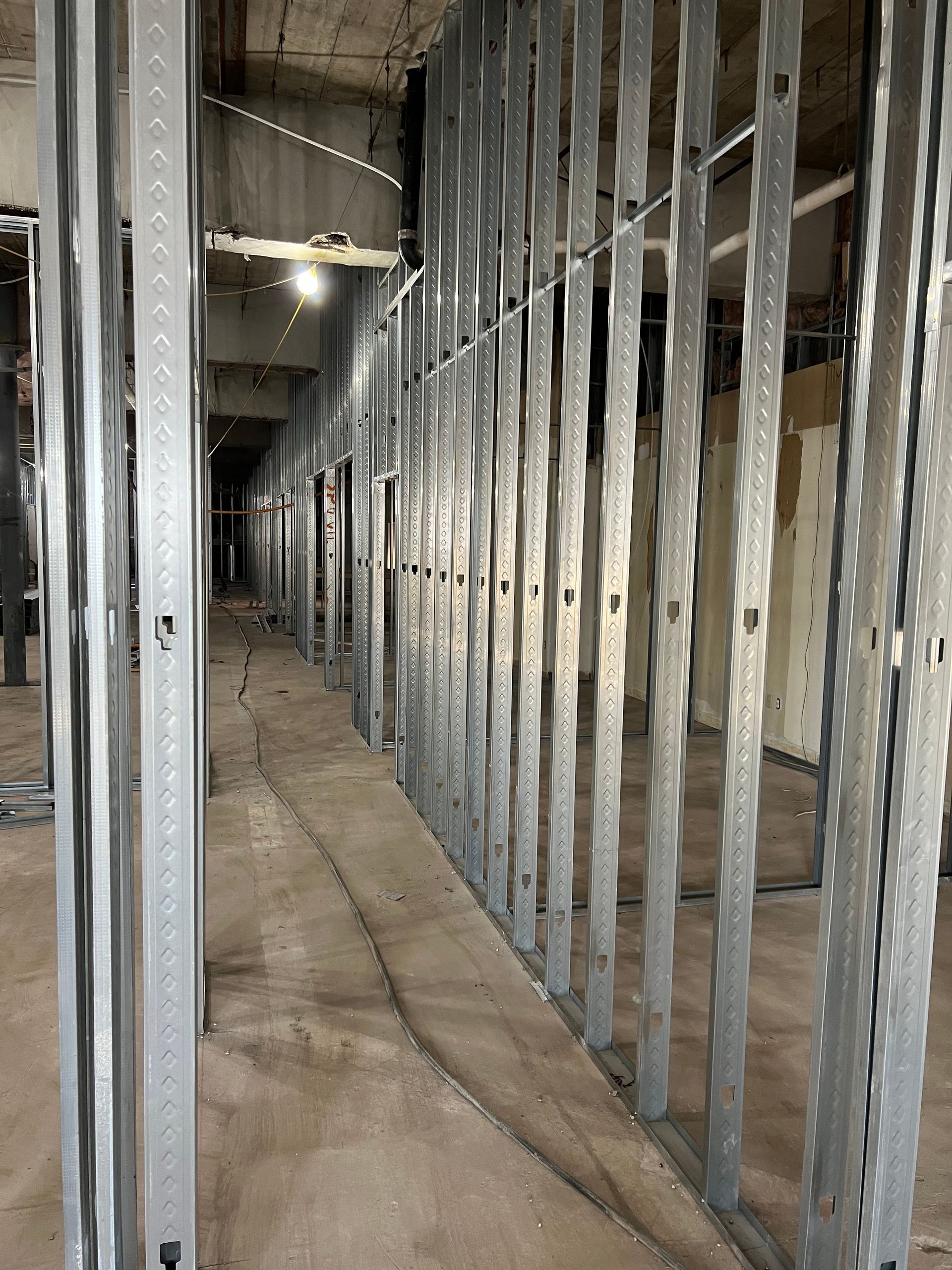 Metal studs forming a wall in a construction site.