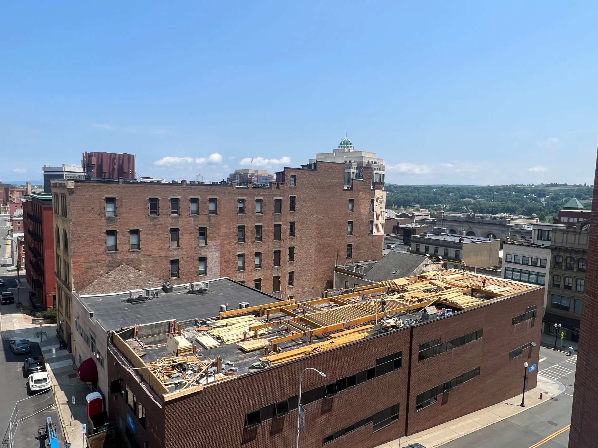 Buildings with exposed roof, street, and blue sky.