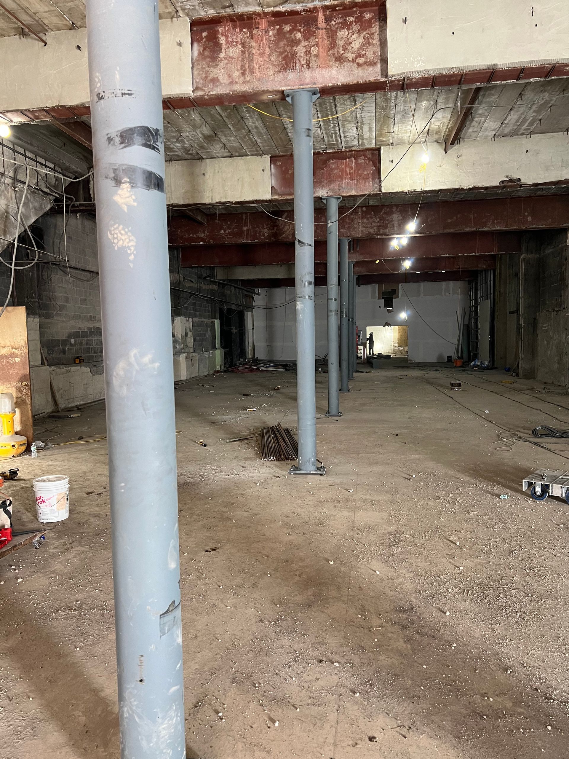 Interior of a building under construction. Concrete walls, support beams, and metal support poles.