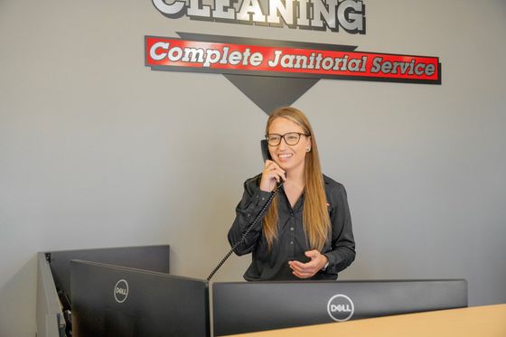 Woman in black shirt on phone at front desk under