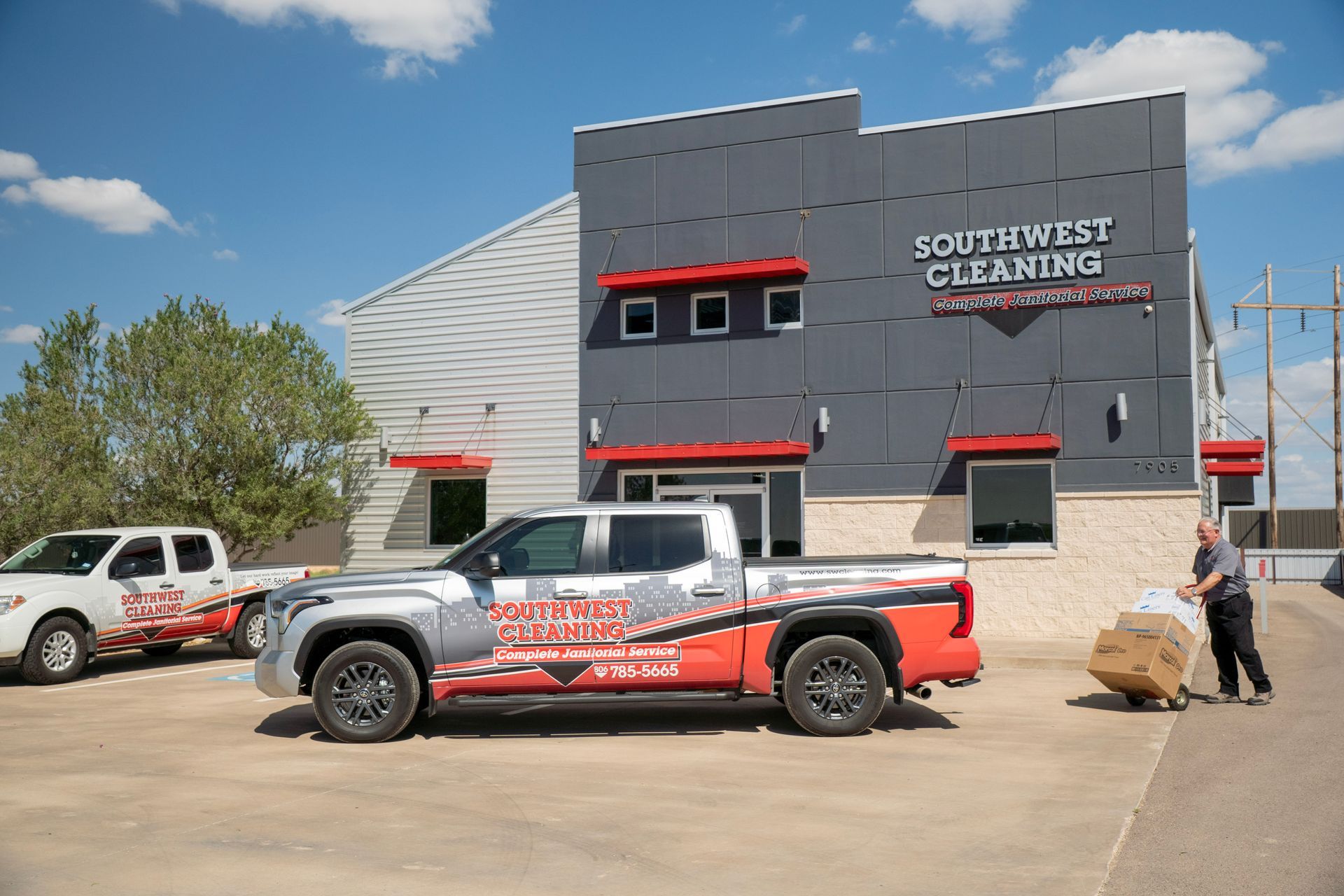 Two Southwest Cleaning trucks parked in front of their building; a man pulls a cart.