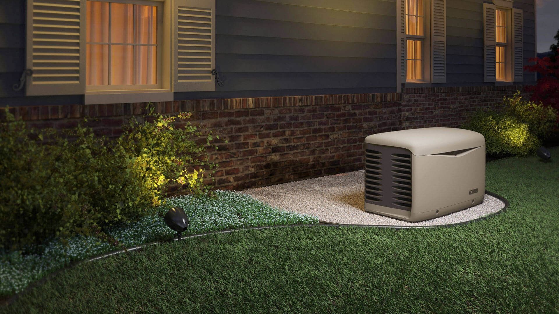 Generator outside a house, providing power. Dark blue siding, lit windows, and green grass.