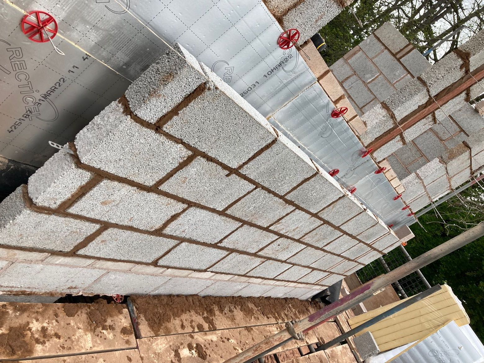 completed cavity block wall A new cavity block wall built on site with ladder and tools
