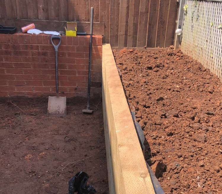 Dyl Garden Wall Build garden wall built by Dyl for Devon Expert Bricklayers in a muddy garden with tools out