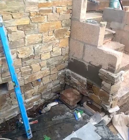 a brick wall built next to a new pathing driveway cleaned and new between two properties 