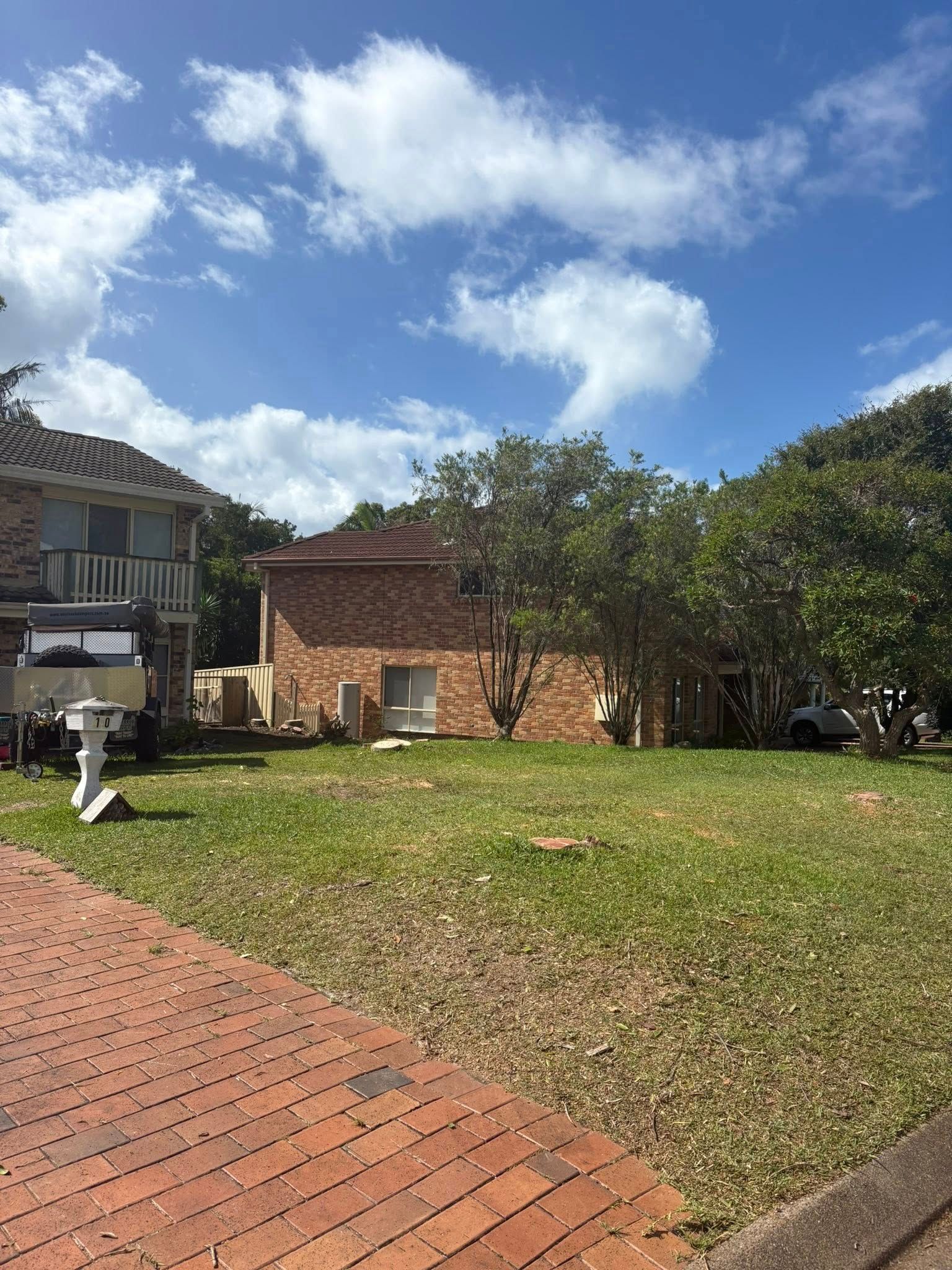 A Brick House Surrounded by Trees and a Grassy Lawn — All One Arb Tree Service In Kempsey, NSW