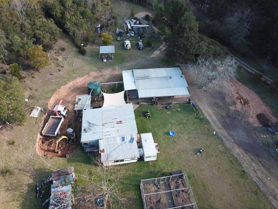 An Aerial View of A House in The Middle of A Field Surrounded by Trees — All One Arb Tree Service In Bonny Hills, NSW