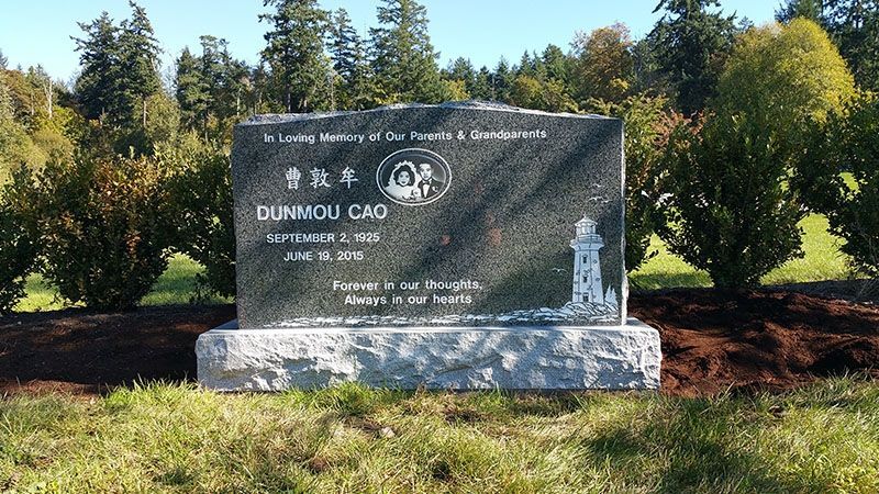 a gravestone in a cemetery with trees in the background .