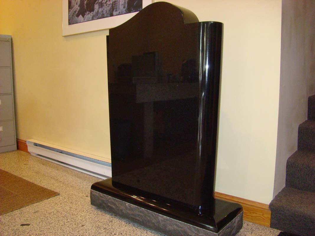a black gravestone is sitting in a room next to stairs