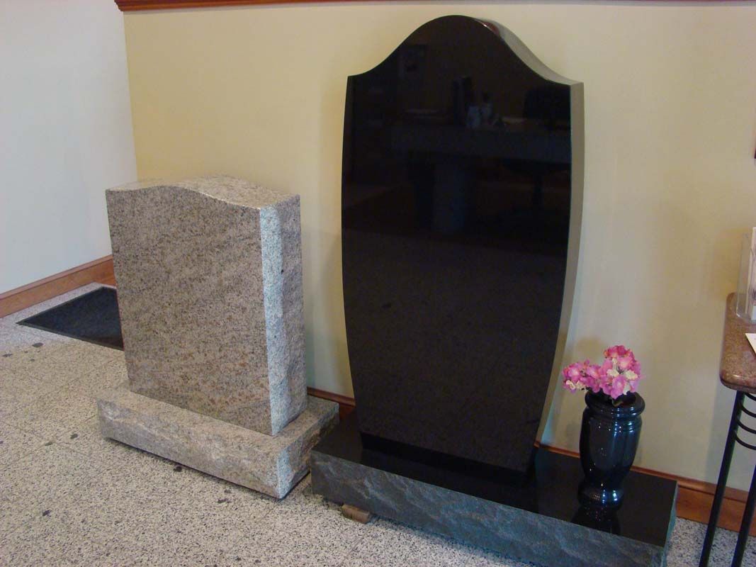 two gravestones are sitting next to each other in a room .