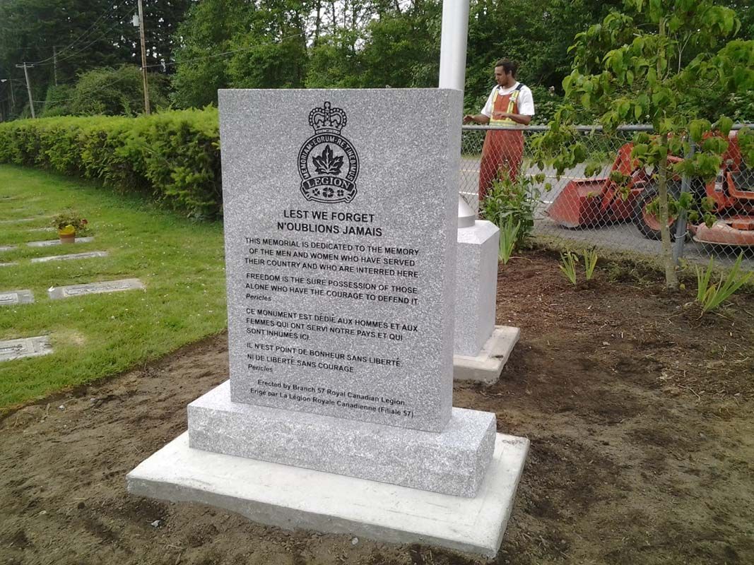 a man is standing next to a gravestone in a cemetery .