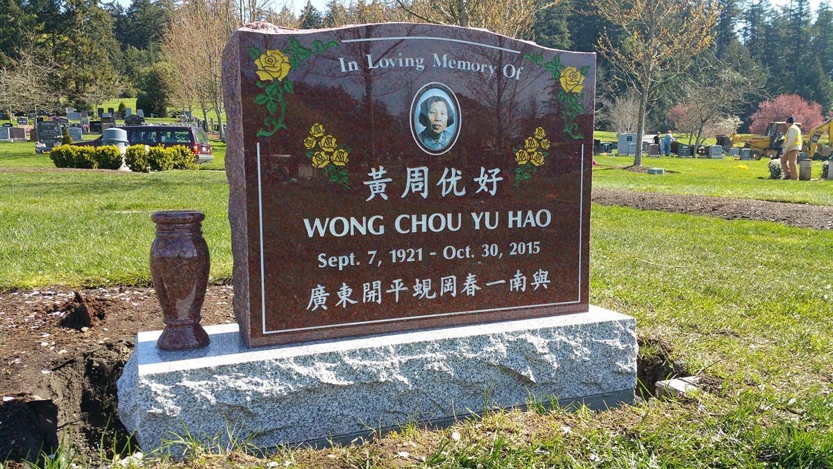 a gravestone for wong chou yu bao is in a cemetery .