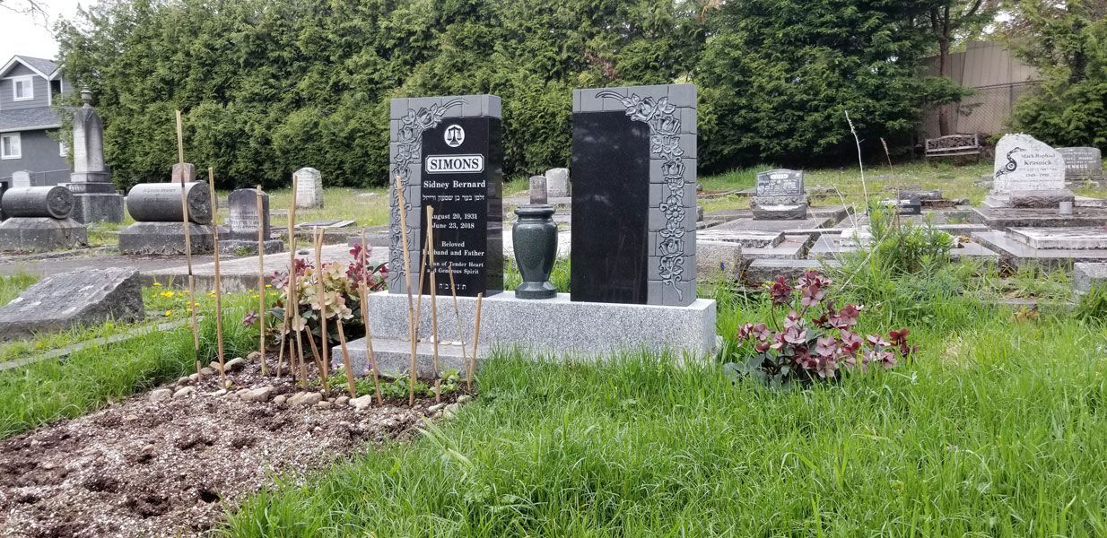 There is a grave in the middle of a cemetery.