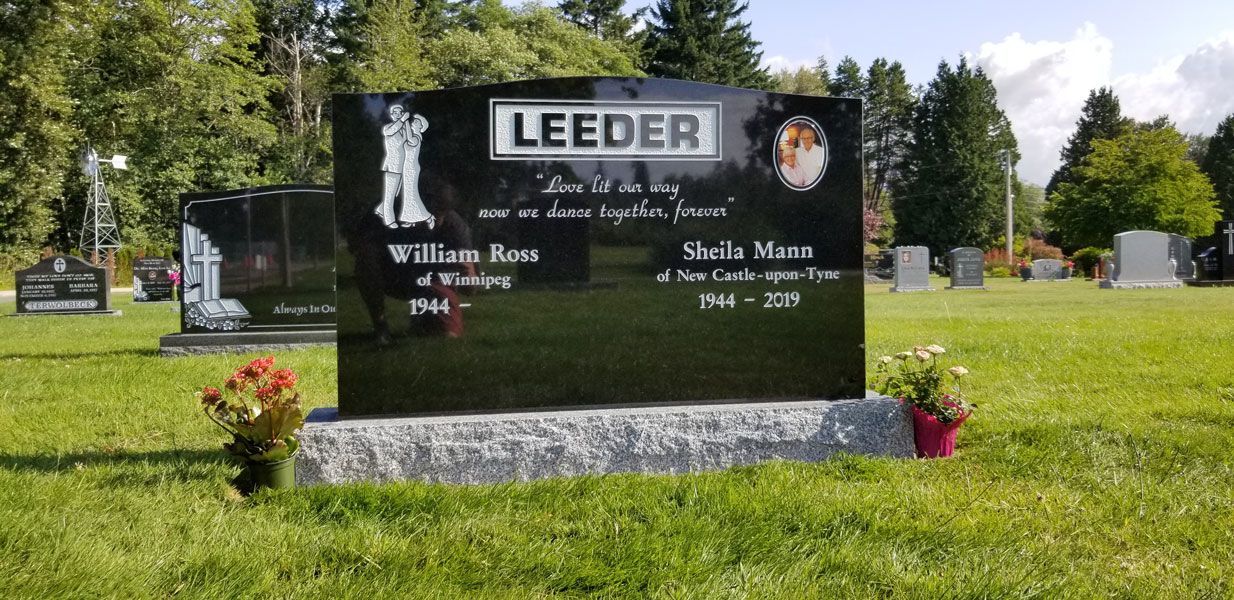A black gravestone in a cemetery with the name leeder on it
