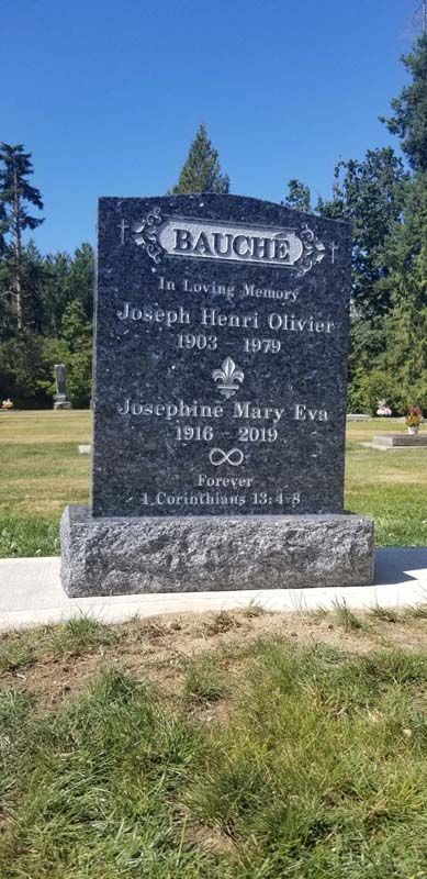 A gravestone in a cemetery with a blue sky in the background.