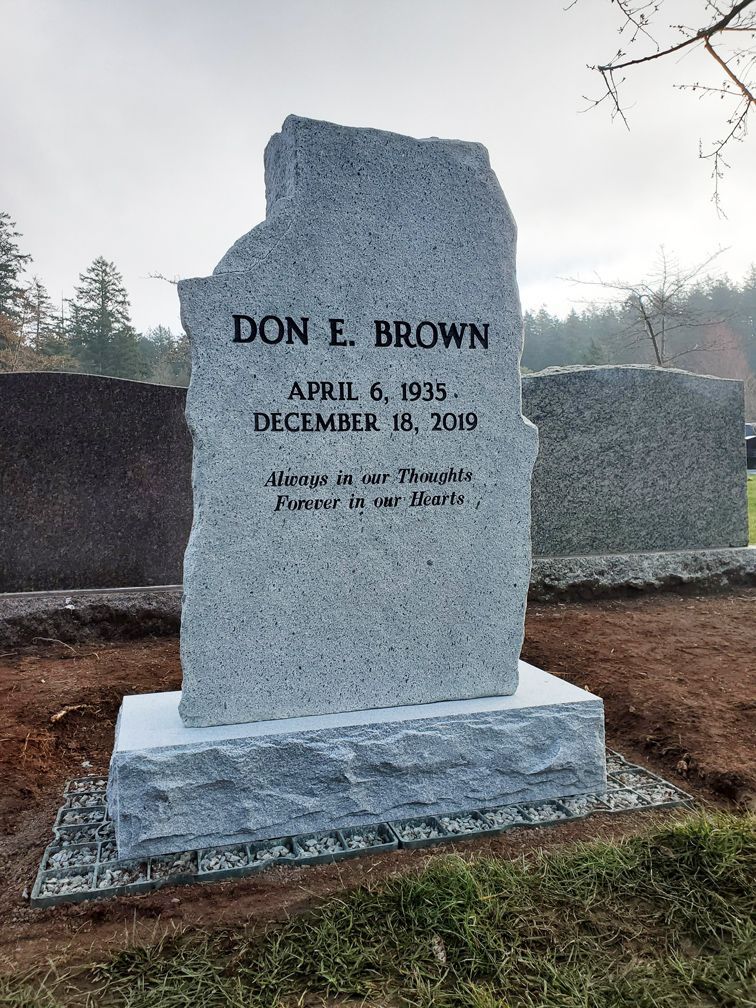 a gravestone for don e. brown is in a cemetery .