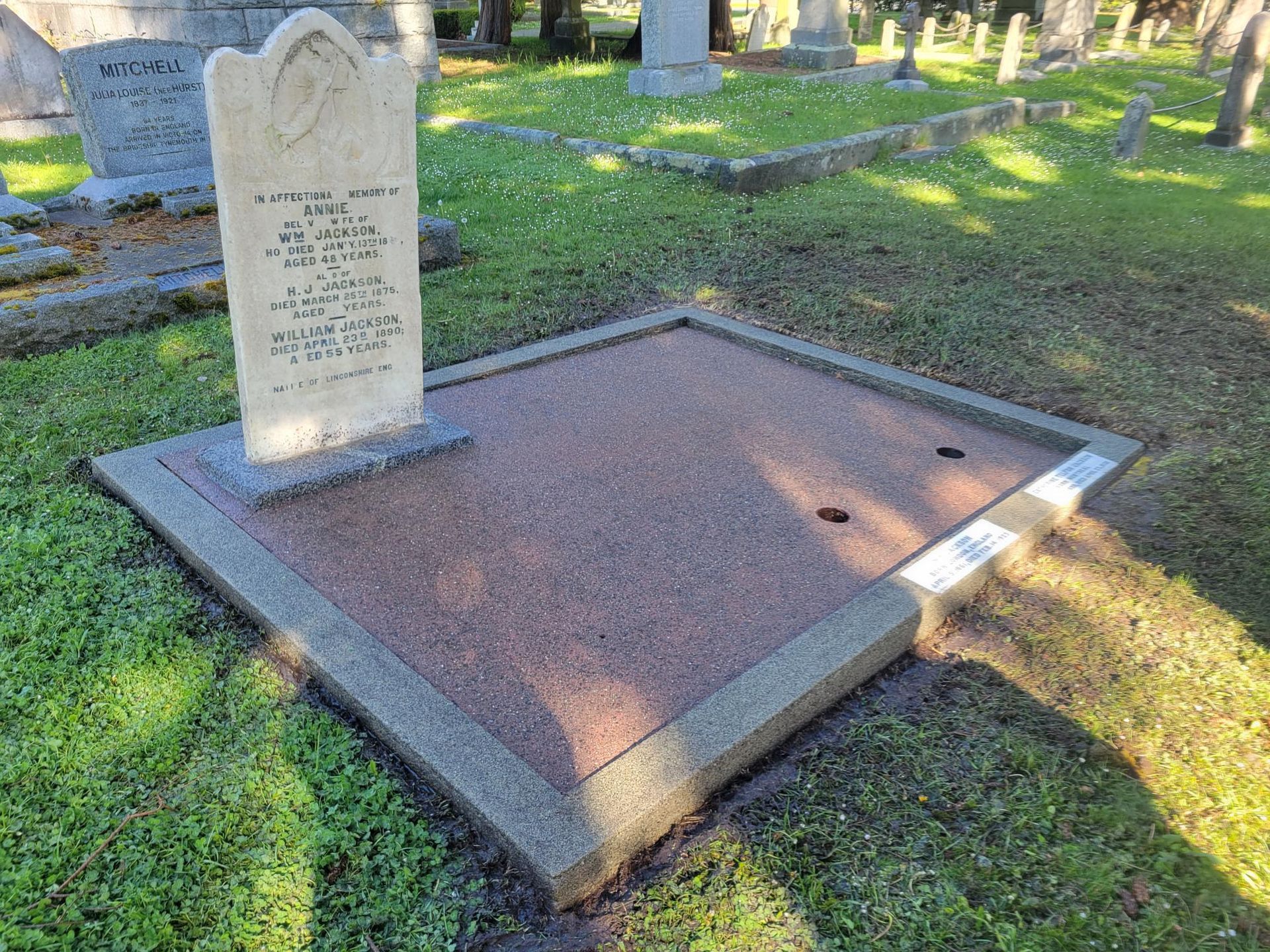 there is a grave in the middle of a cemetery .