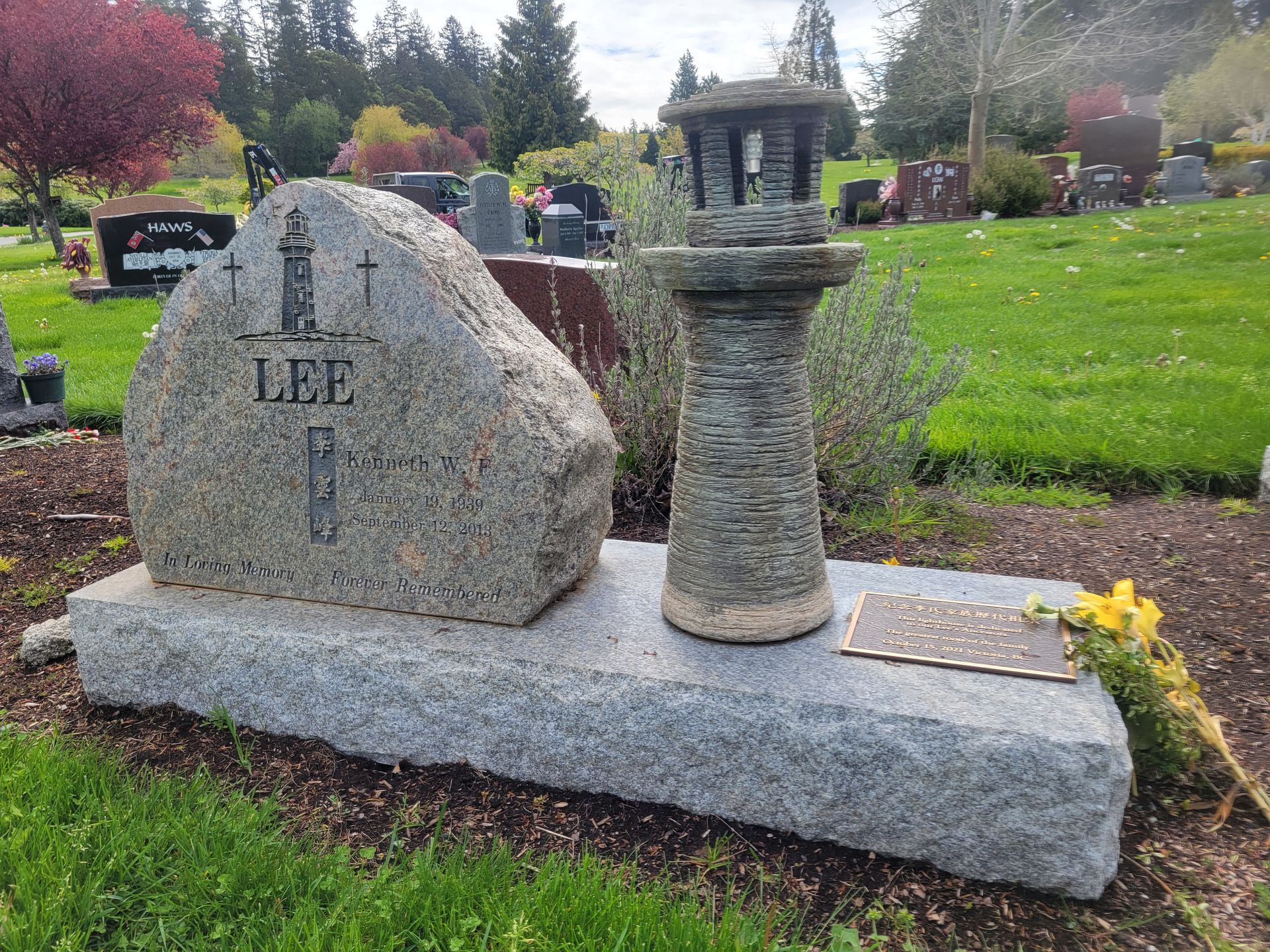 a gravestone in a cemetery with a lantern on top of it .