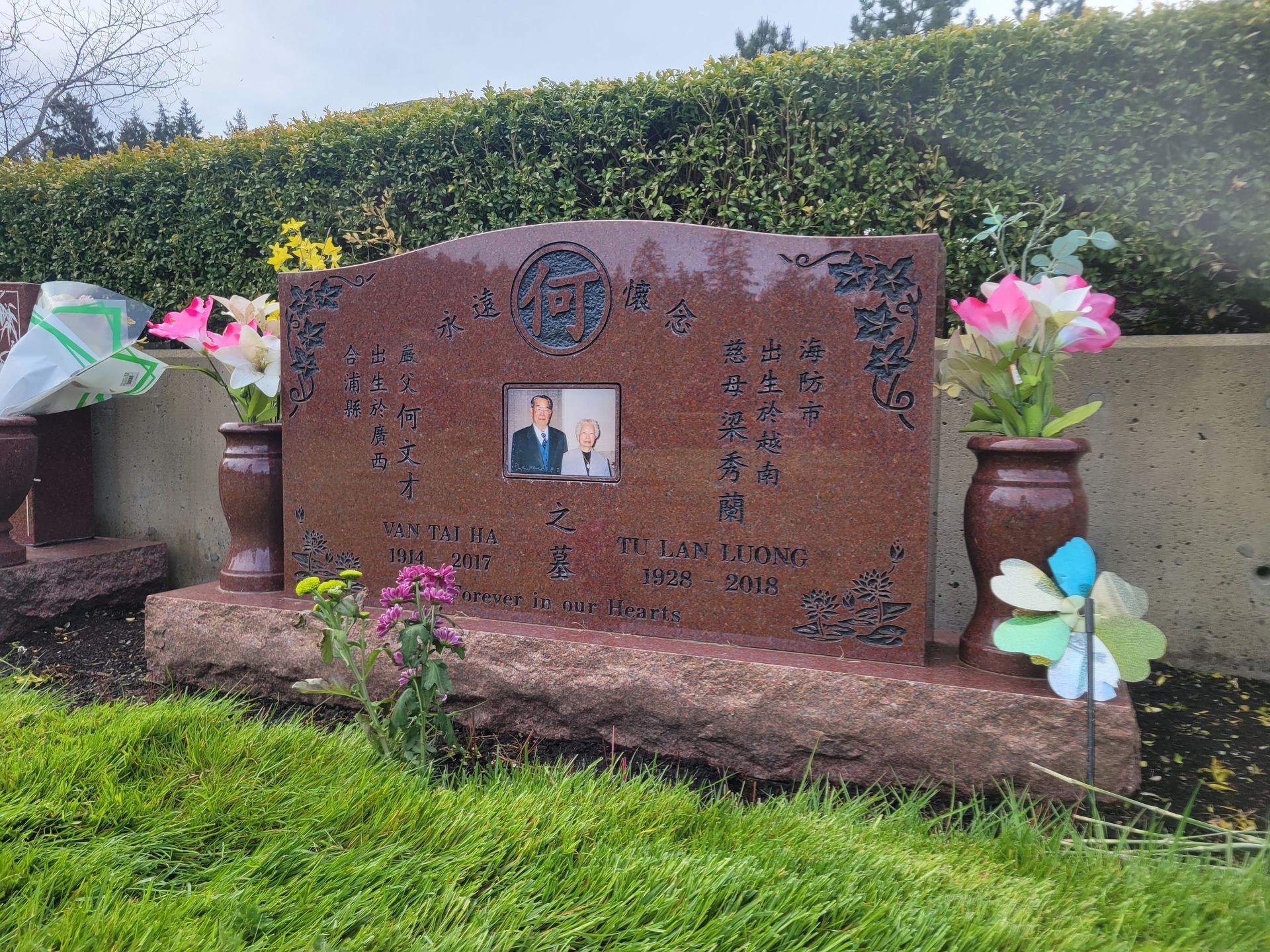 a grave with flowers and a picture of a man on it