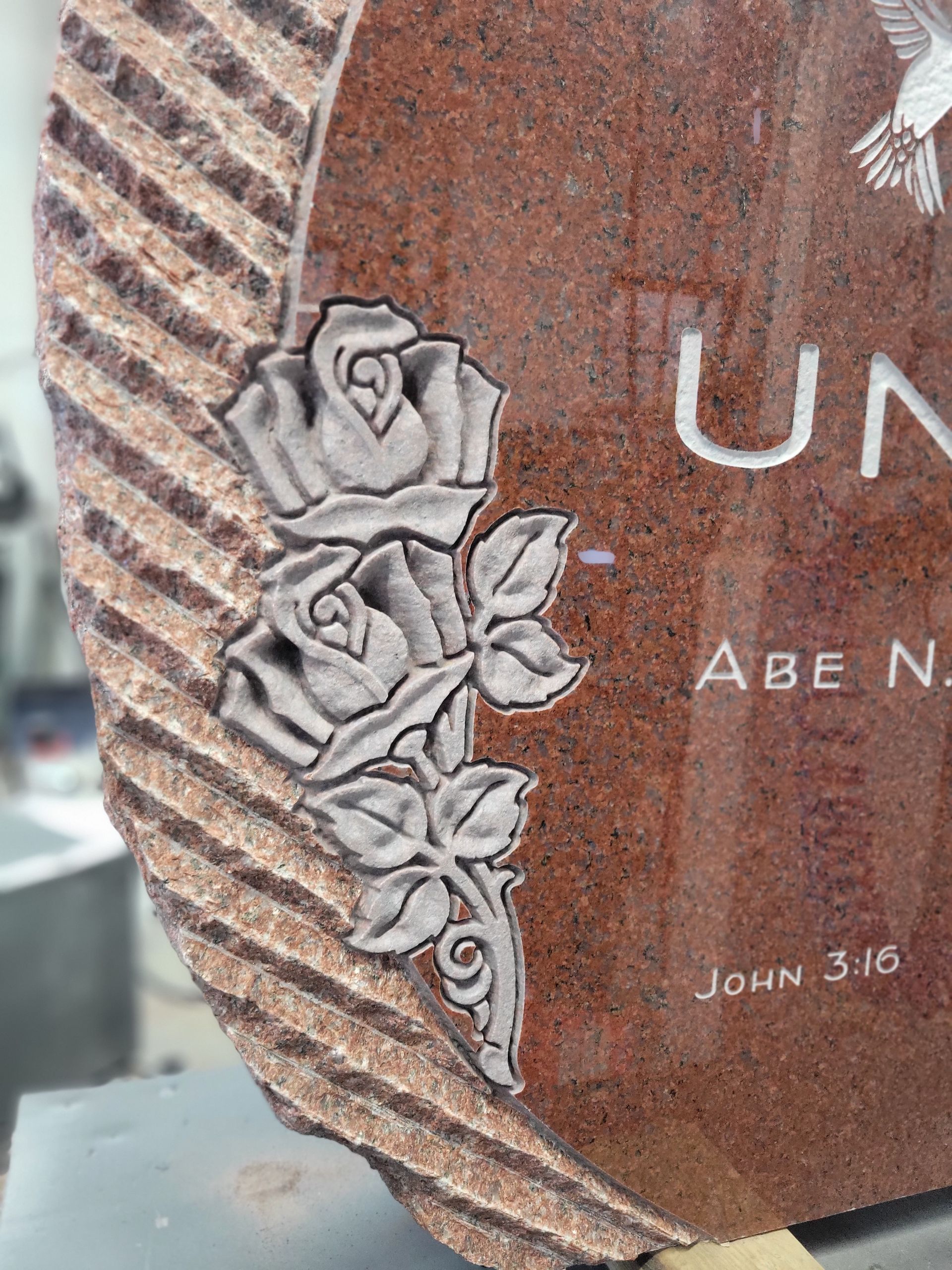 a gravestone with roses and a dove on it