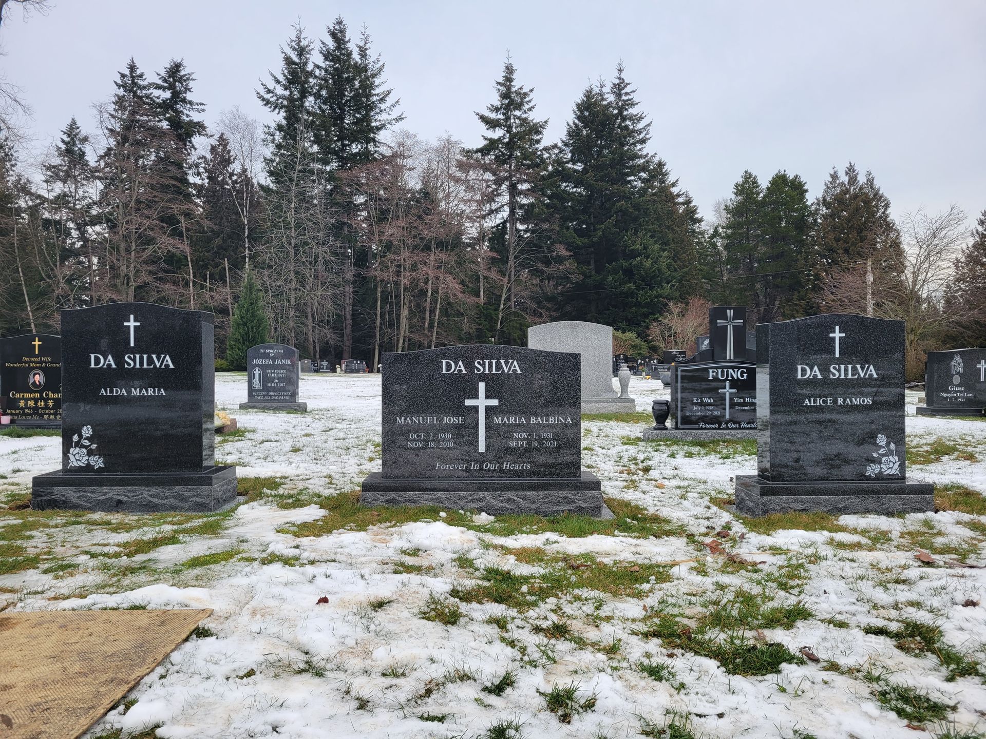 three graves in a cemetery with snow on the ground