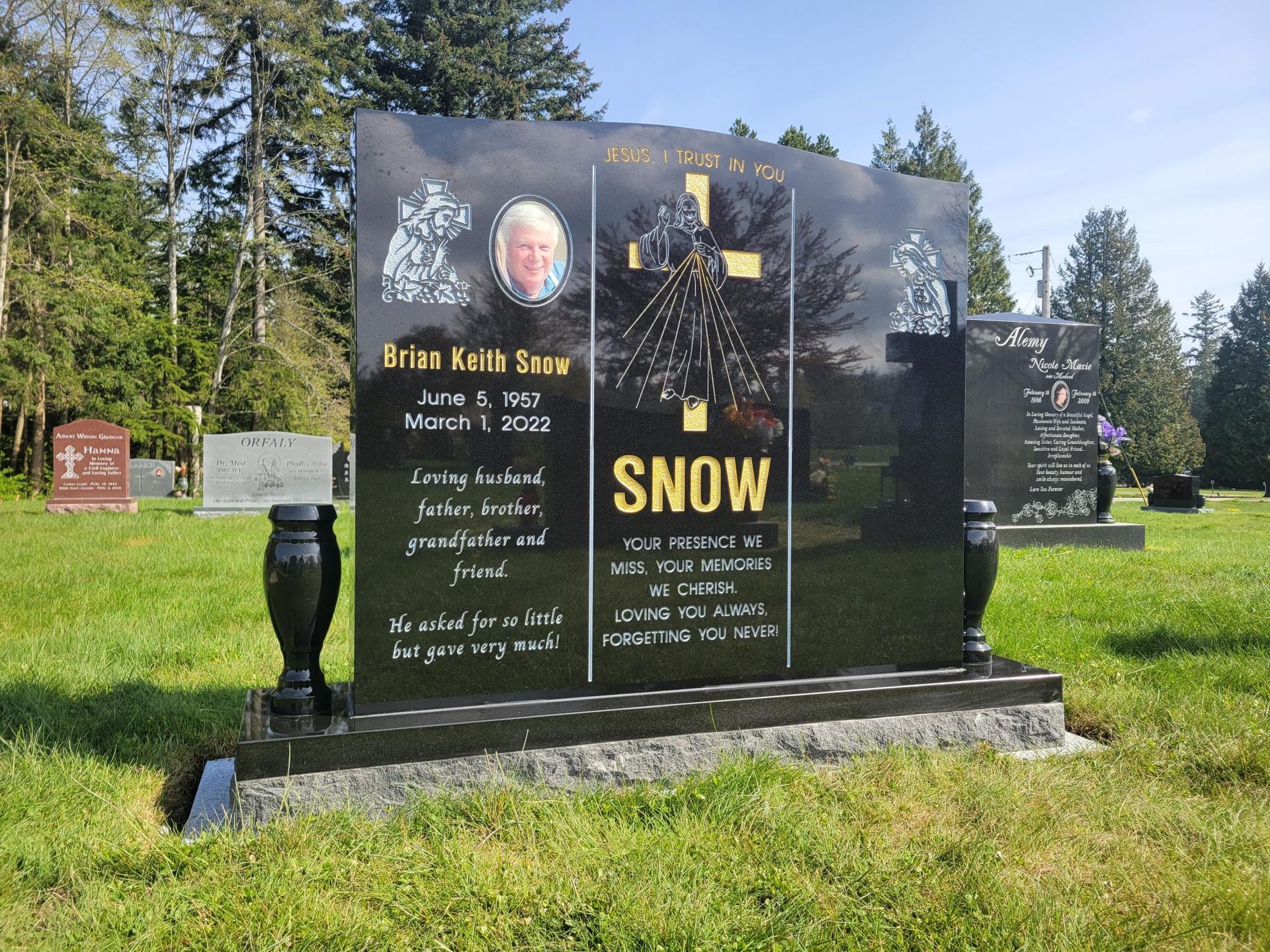 a black gravestone in a cemetery with the name snow on it