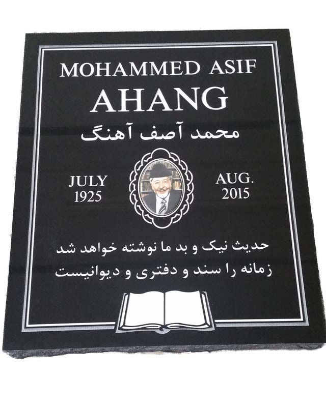 A black headstone with white lettering and photo

