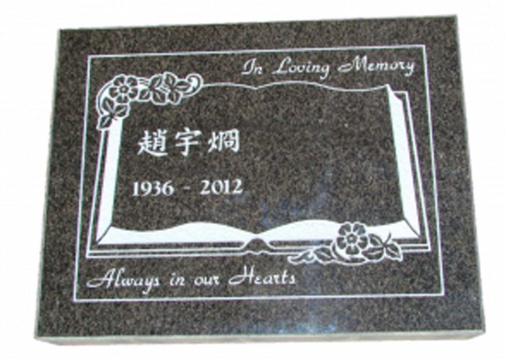 A gravestone with a picture of an open book and the words `` in loving memory '' written on it.